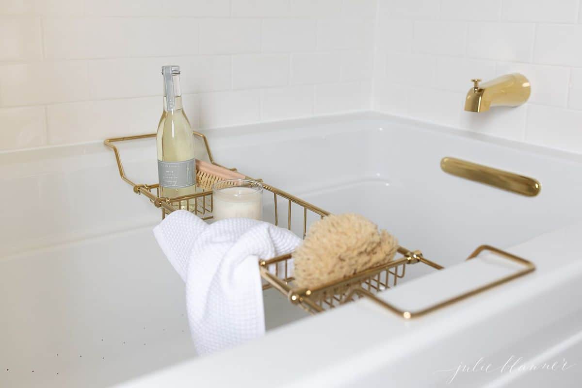 空气浴缸与黄铜沐浴配件和黄铜沐浴托盘充满了沐浴用品。