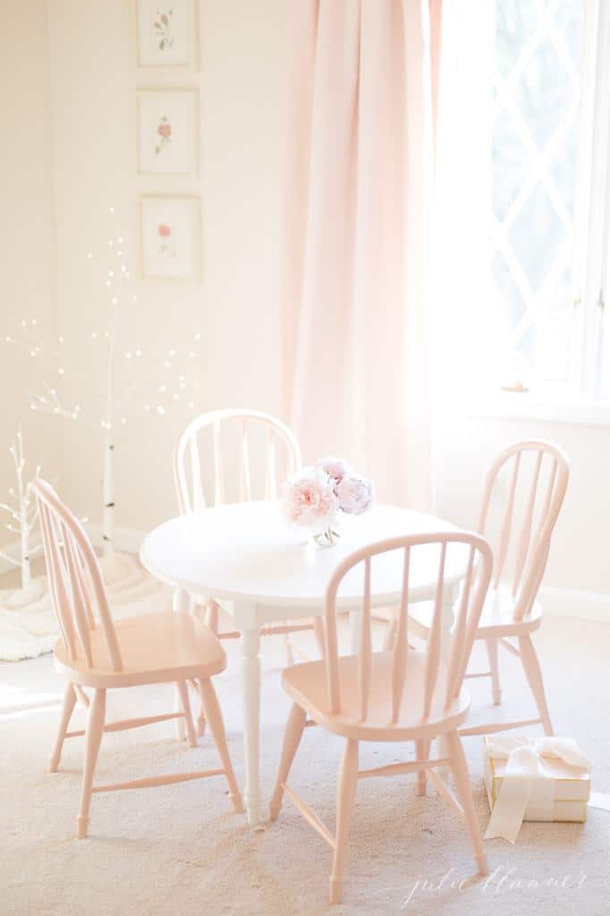 白色的女性卧室，粉红色的桌椅，圣诞装饰点缀整个空间。