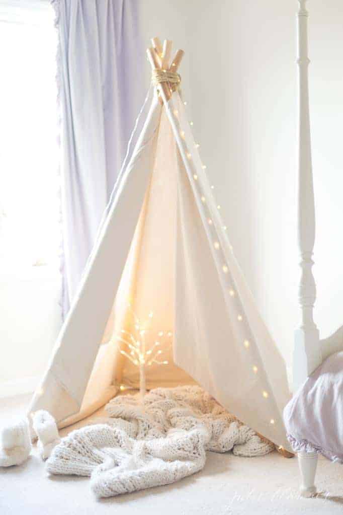 白色卧室里的白色帐篷，室内装饰温馨舒适。