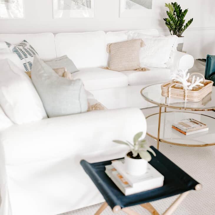 白色的客厅，白色的沙发，玻璃咖啡桌和一对藏青色的椅子。