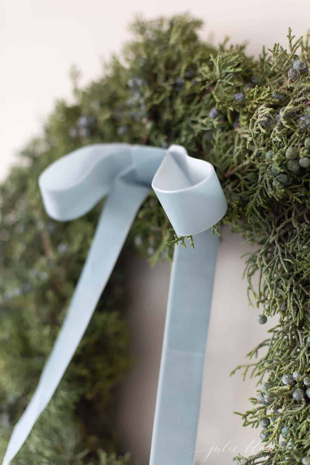 特写的杜松花环与天鹅绒花环为蓝色圣诞装饰。