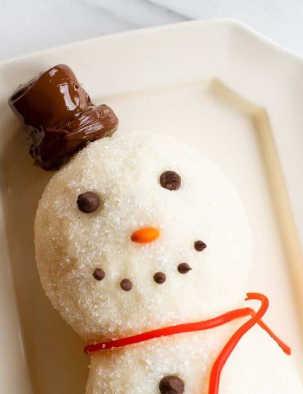白色表面，雪人芝士球在盘子上，巧克力片微笑。