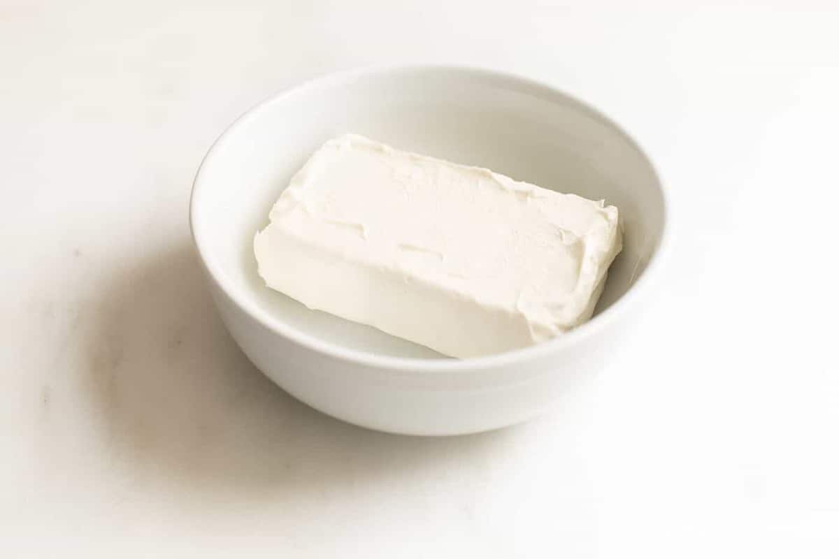 白色的碗，里面有一块奶油奶酪。