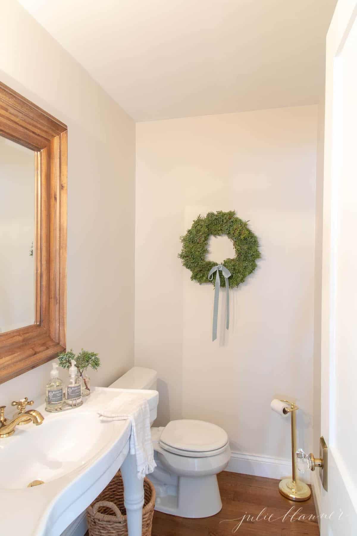 浴室里的杜松花圈，配有木质镜子和巴黎风格的水池