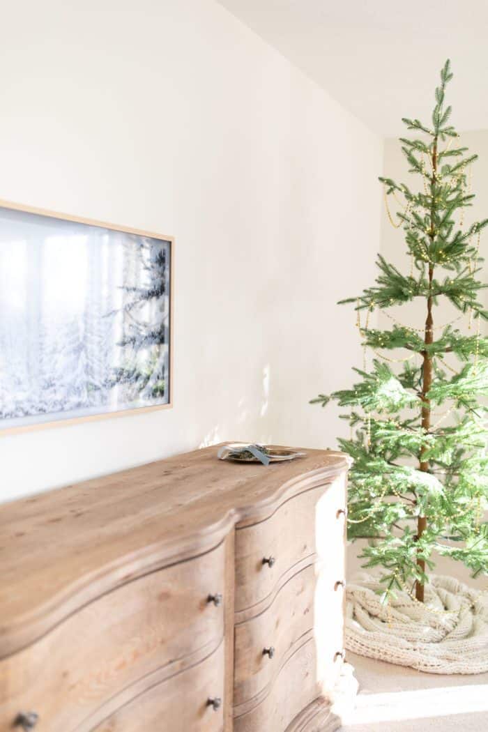 圣诞卧室装饰与一个漂亮的树，软木梳妆台和艺术电视。
