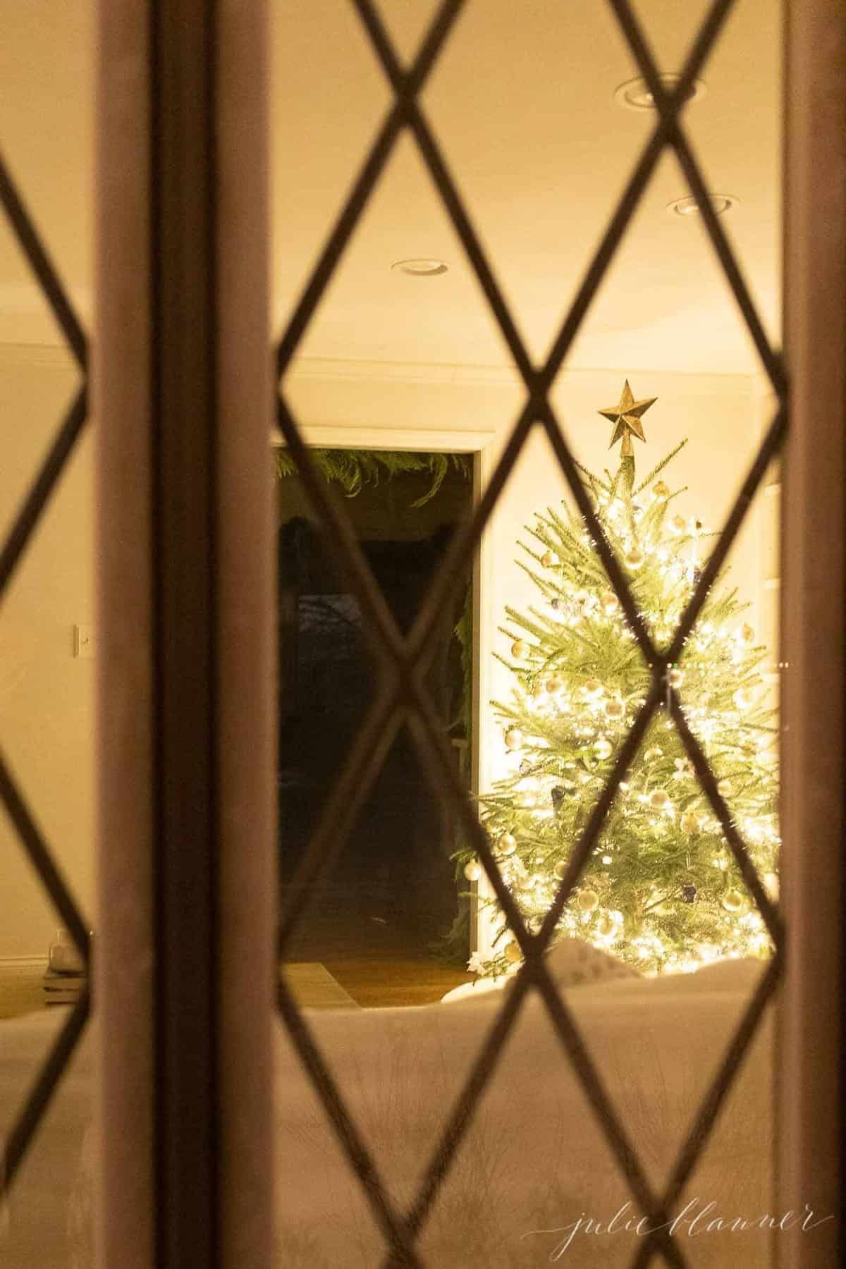 从外面望向客厅的圣诞树景象，在夜晚。