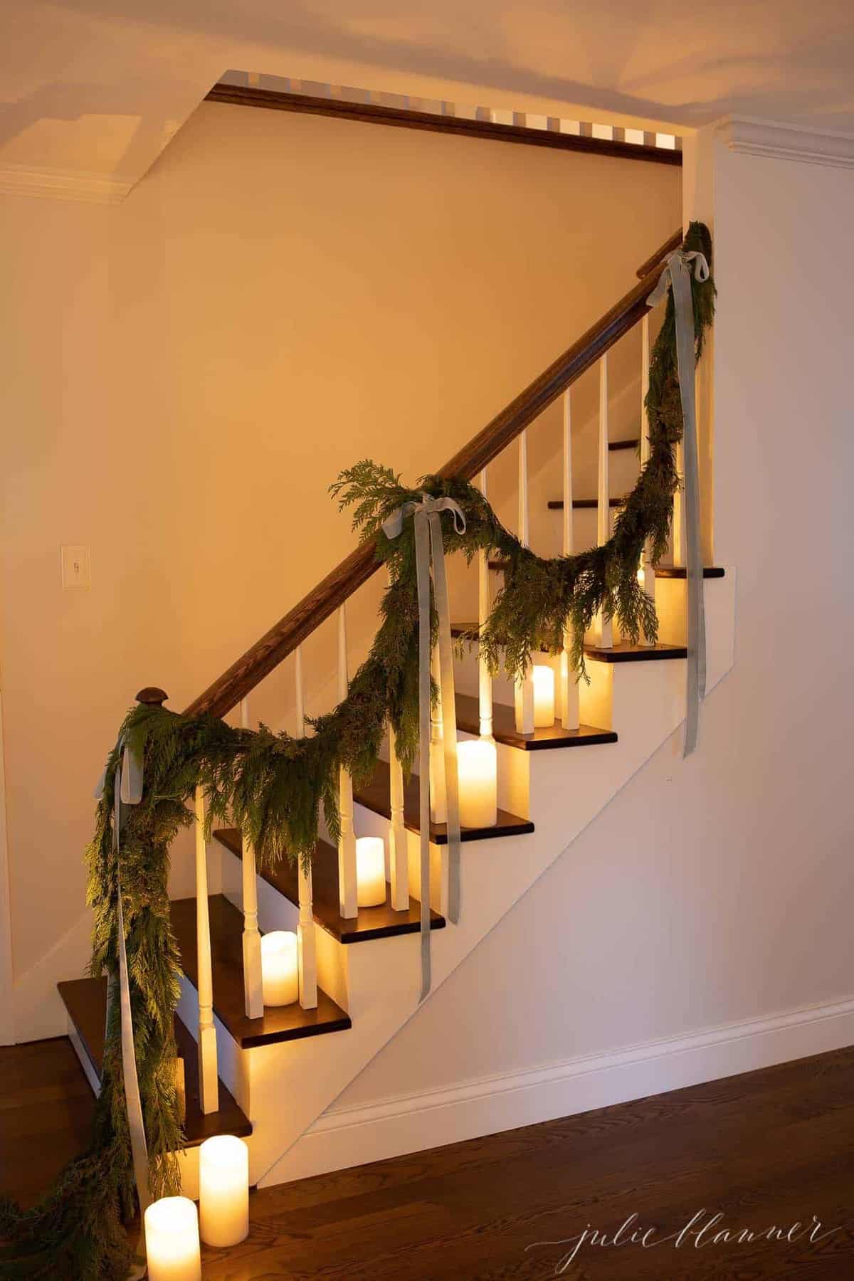 白色的墙壁，木制楼梯装饰着蜡烛和花环在圣诞节。