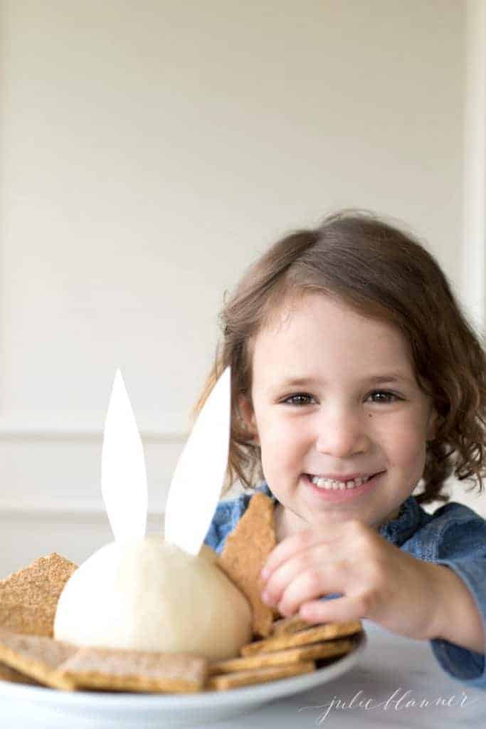 小女孩吃着兔子耳朵的芝士球甜点。