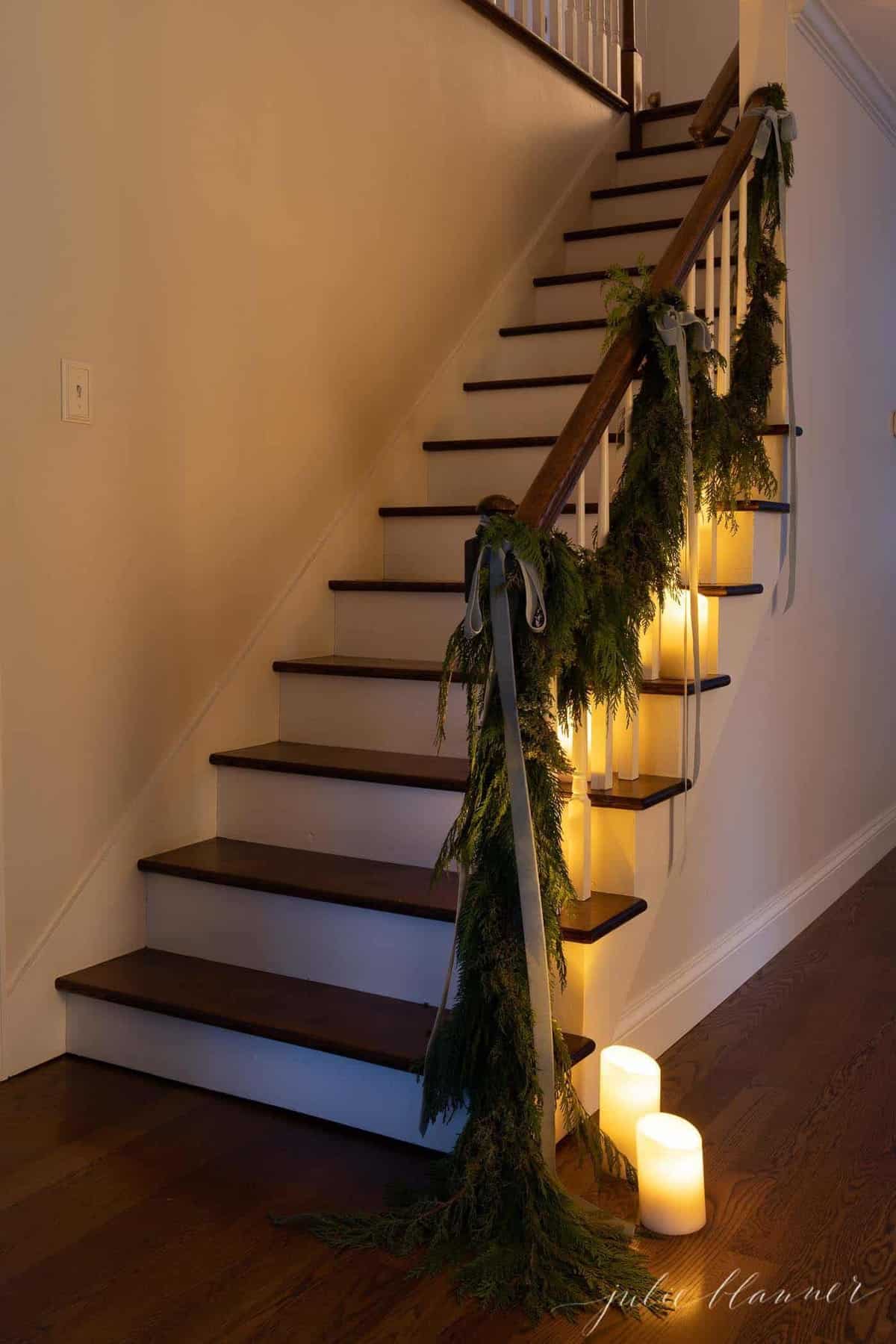 白色的墙壁，木制楼梯装饰着蜡烛和花环在圣诞节。
