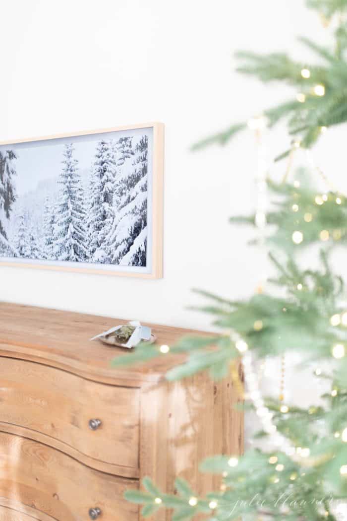 圣诞卧室装饰有一棵漂亮的树，柔软的木制梳妆台和艺术电视。