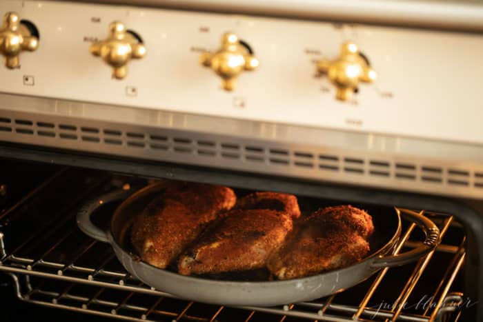 看着一个用铸铁平底锅烤着焦黑鸡胸肉的烤箱。gydF4y2Ba
