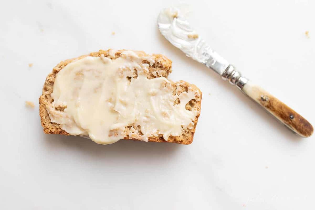 一片涂了黄油的面包，把刀放在一边，放在白色大理石的表面上。gydF4y2Ba
