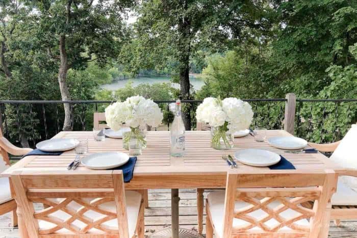 木制露台桌子与绣球花的中心，地方设置，湖景的背景。