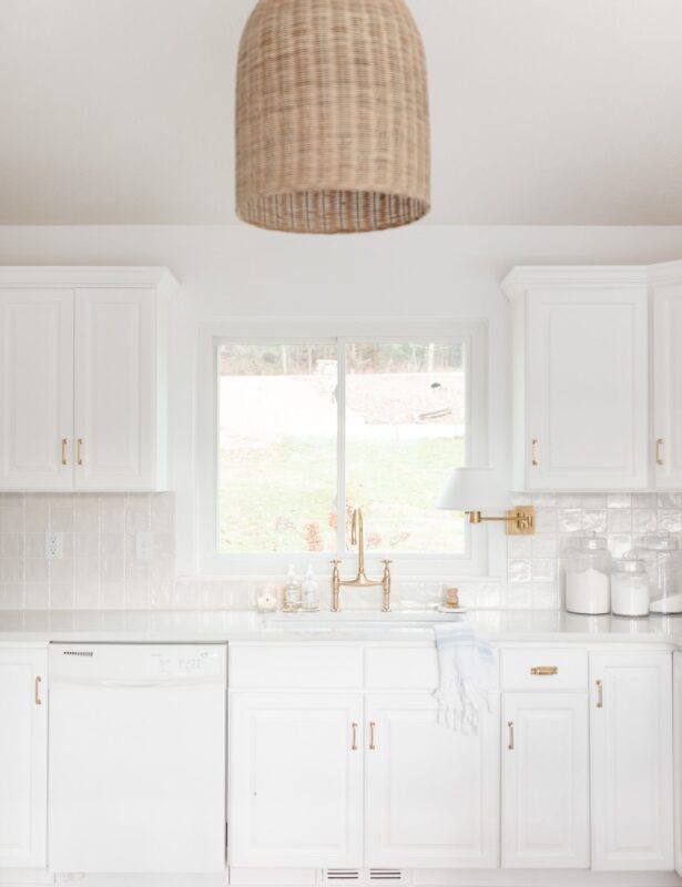 白色厨房水槽，带有黄铜龙头和有组织的台面
