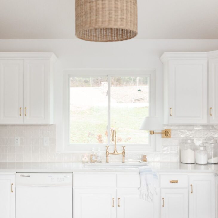 白色的厨房洗涤槽，黄铜水龙头和整齐的台面