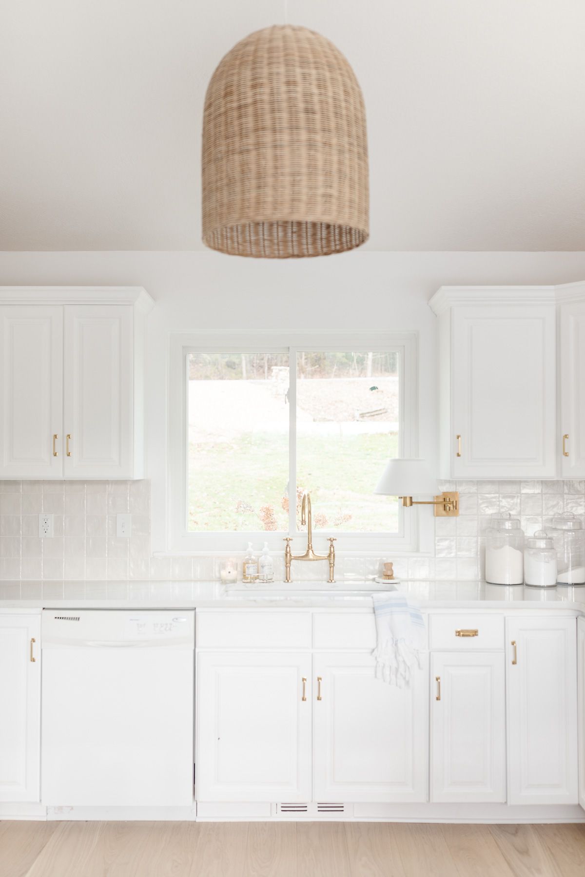 白色的厨房水槽，黄铜水龙头和整齐的台面