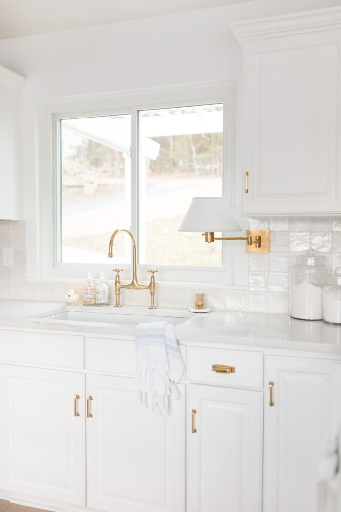 白色的厨房水槽，黄铜水龙头和整齐的台面
