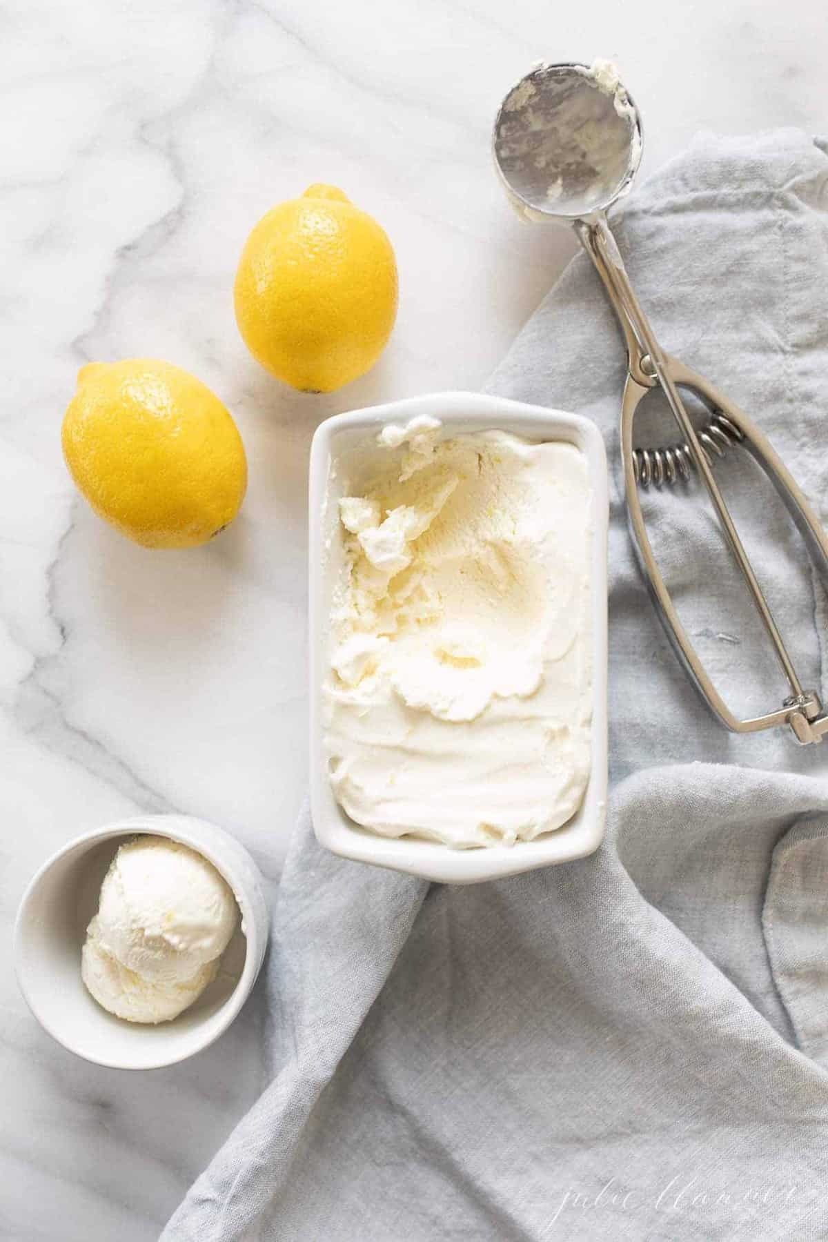 一个白色的陶瓷盘子里装满了自制的梅耶柠檬冰淇淋，柠檬和冰淇淋舀到一边。