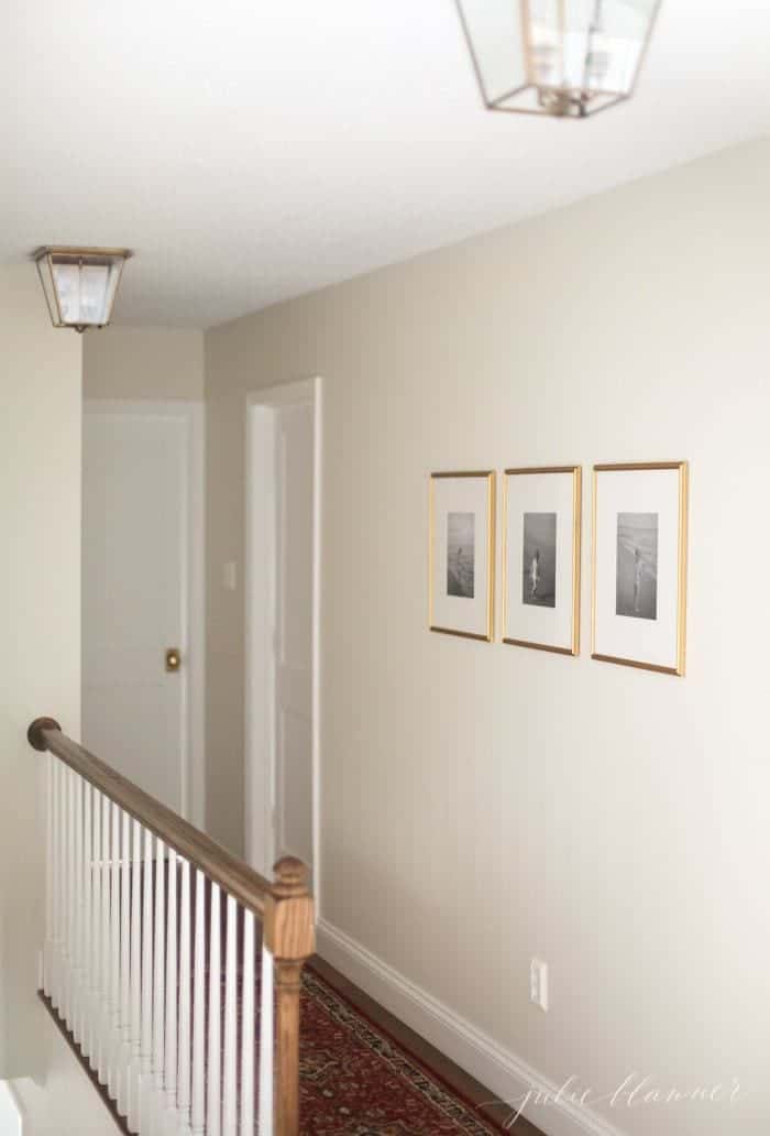 白色走廊，有3张简单的框架图片在一个简约的房子里。
