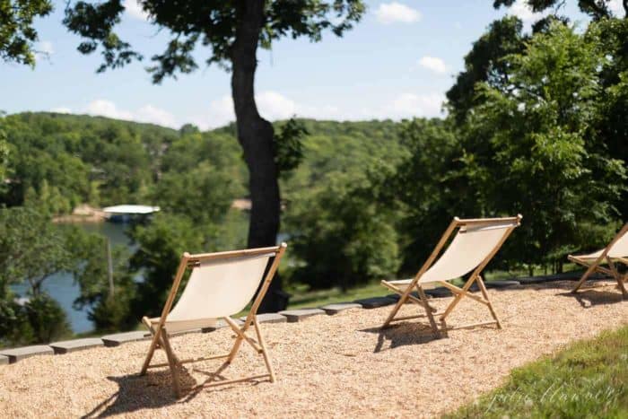 折叠椅在安静的露台上，简单的生活与绿树成荫的湖景。