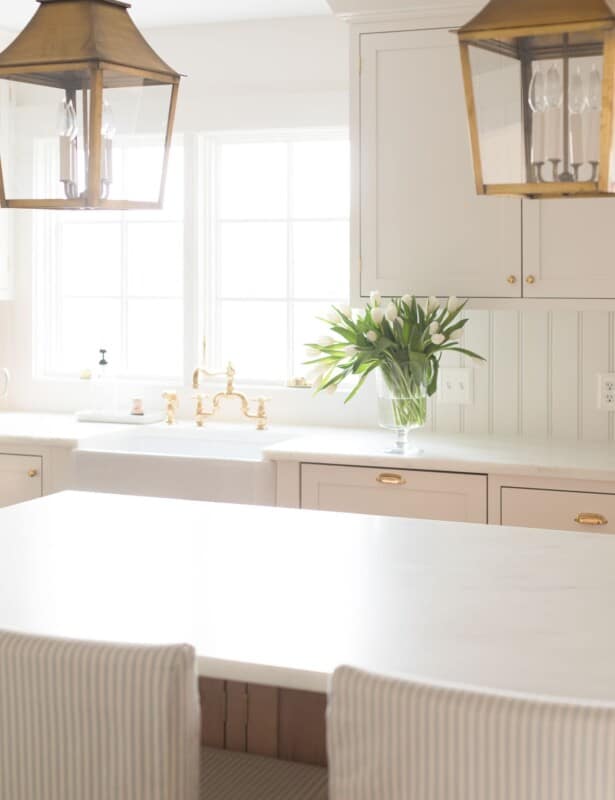 白色极简主义厨房，柜台顶部有一个花瓶。