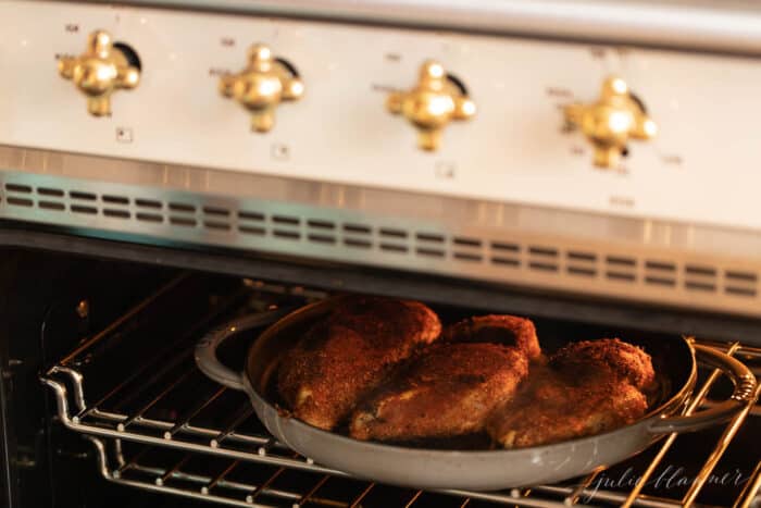 烤箱里有一个铸铁锅，里面有三个烤黑的鸡胸肉。gydF4y2Ba