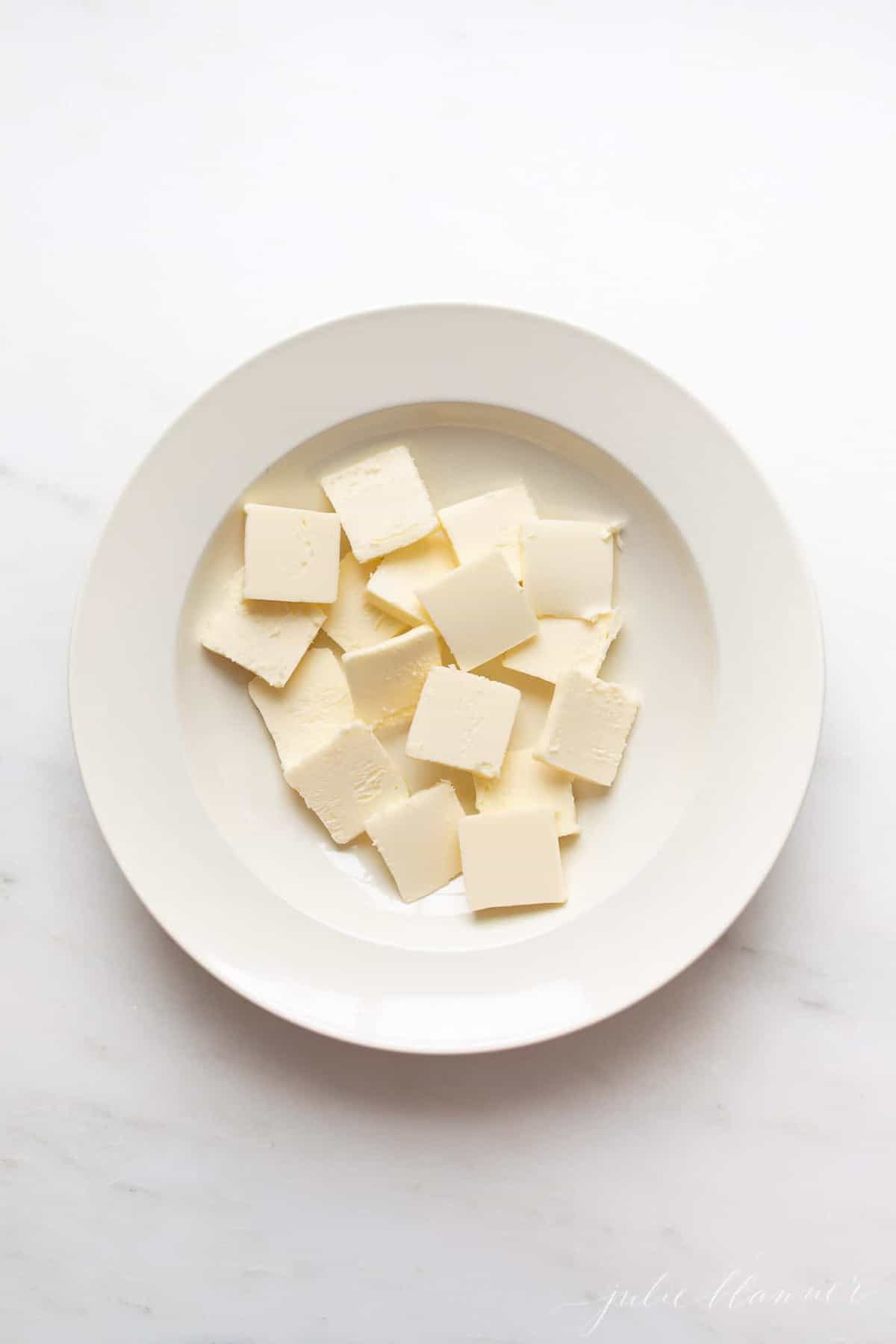 白色的表面，白色的盘子里装满了切好的冷黄油。gydF4y2Ba