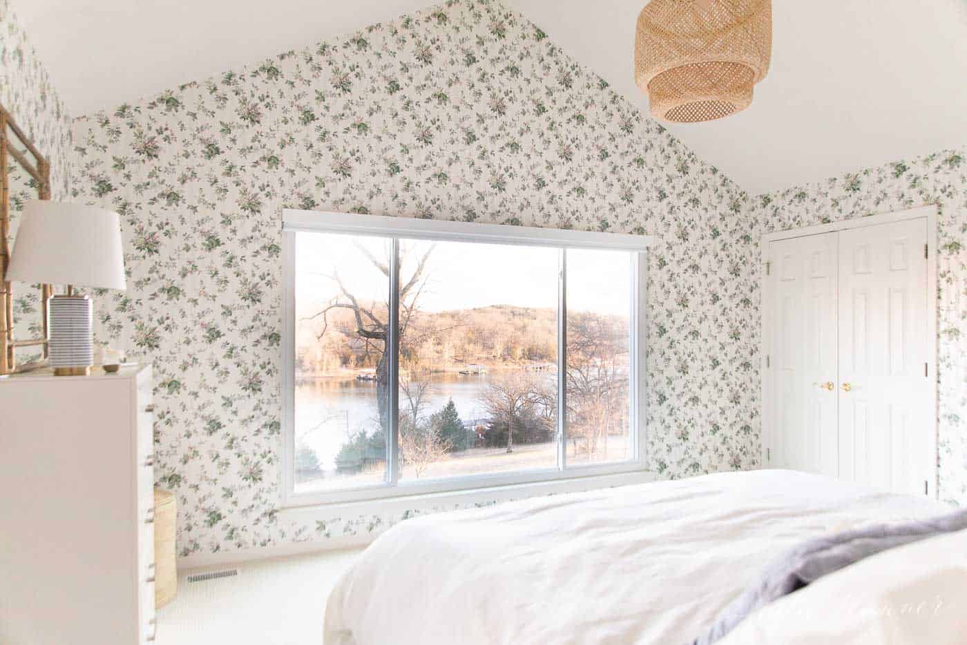 一间白色的卧室，墙上贴着碎花墙纸。