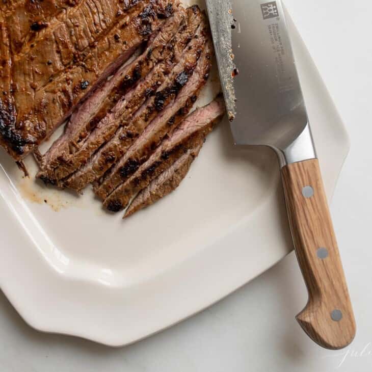 牛排在白色盛肉盘上切成薄片。