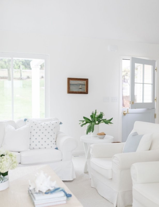 白色客厅，带有白色沙发和枕头，蓝色和白色枕头盖