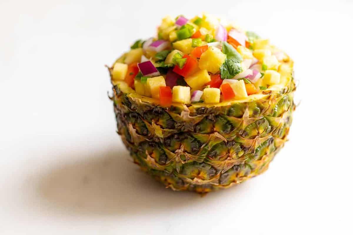 用切好的菠萝做成的新鲜的碗，里面装满了菠萝莎莎酱的配方。