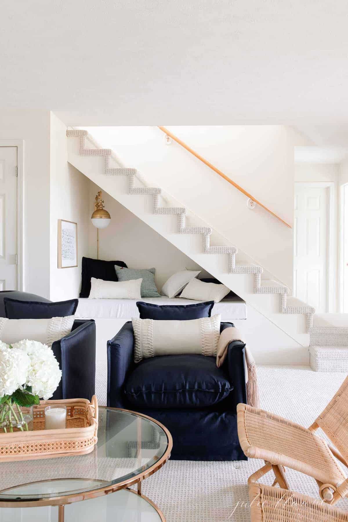 藏青色椅子和金色咖啡桌在前面的楼梯下角落