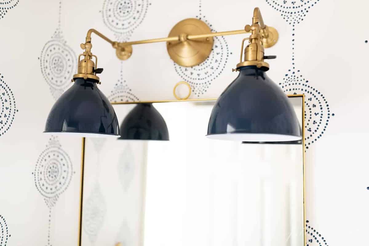 现代浴室想法中的海军和黄铜浴室灯具刷新。