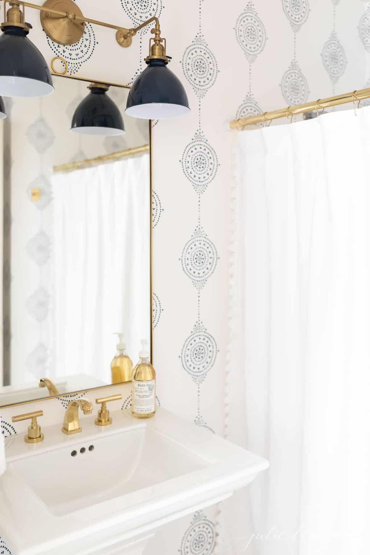 现代浴室，配有海军灯具，海军和白色图案浴室墙纸。