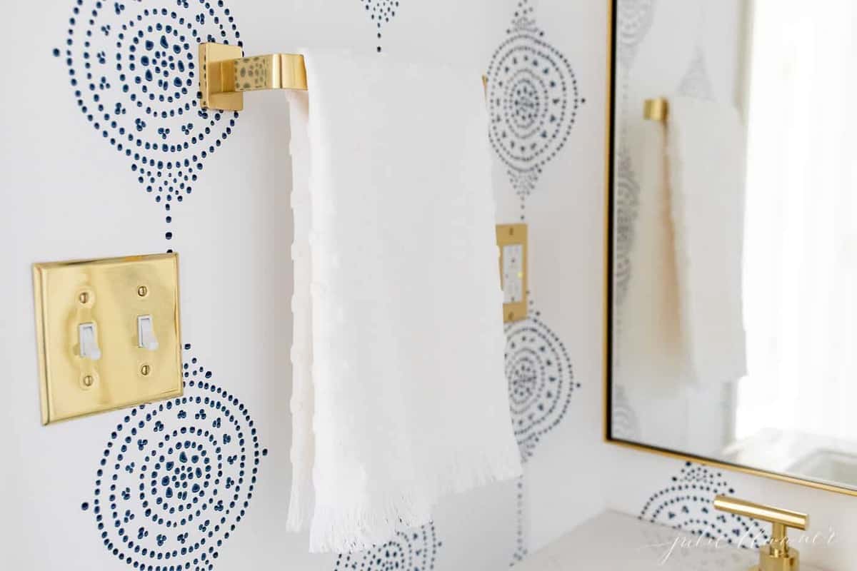 蓝色和白色的Walppers浴室，带有金毛巾杆。