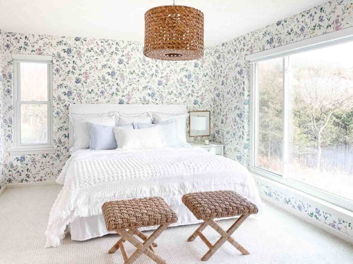 墙纸卧室，白色床上用品藤凳