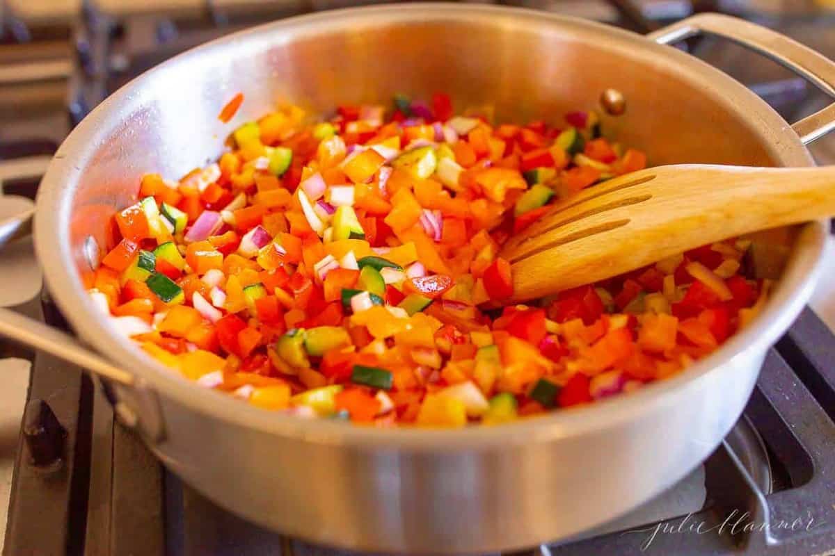 新鲜的蔬菜堆积在银汤锅中，进入蔬菜面食沙拉。GydF4y2Ba