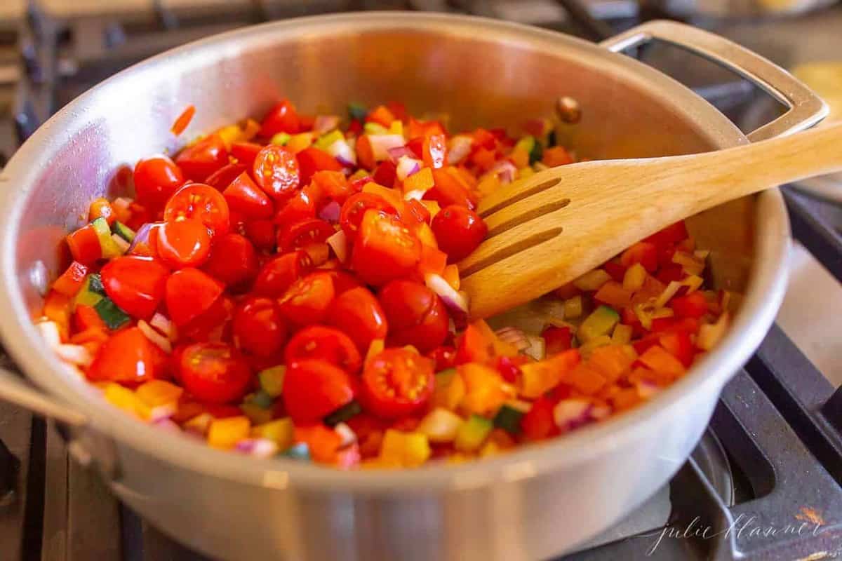 新鲜的蔬菜堆积在银汤锅中，进入蔬菜面食沙拉。GydF4y2Ba