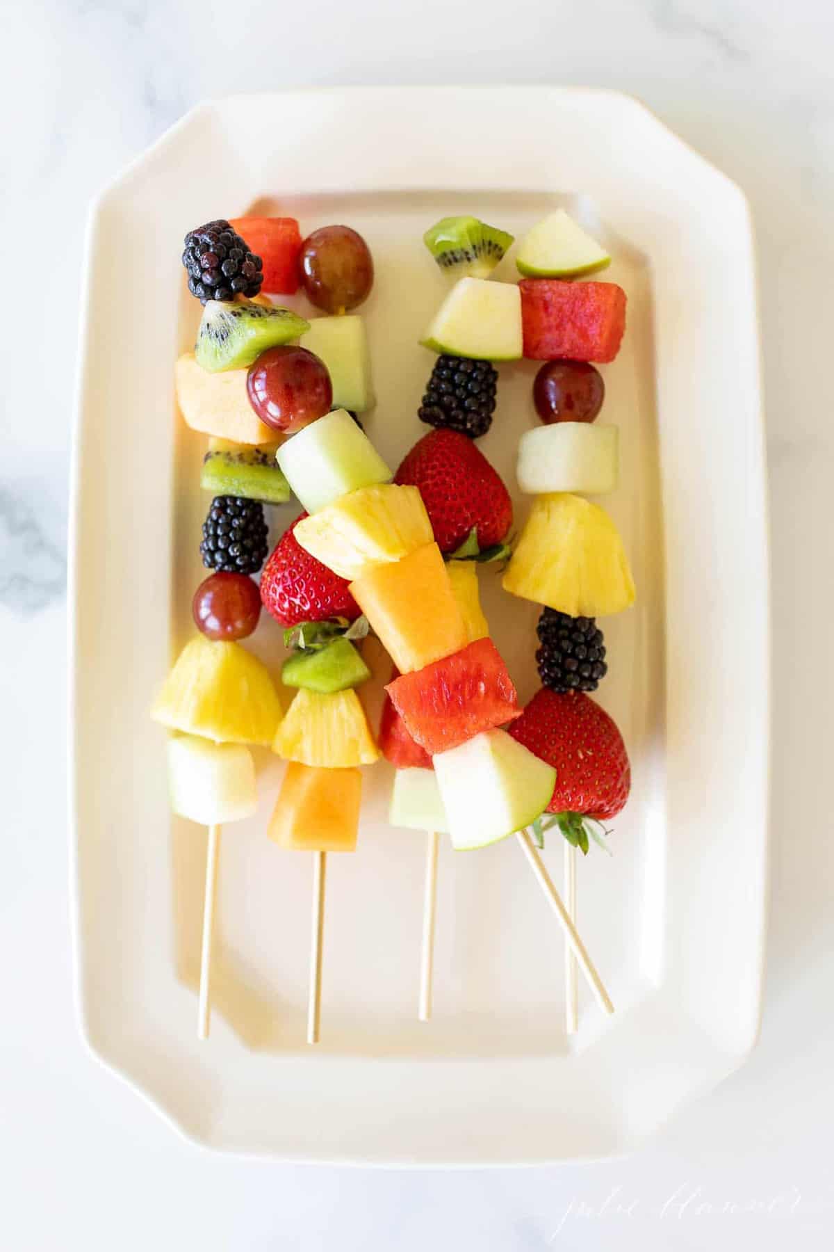 彩色水果串放在白色浅盘上。