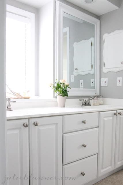 浴室有一个白色的橱柜和灰色的墙壁。