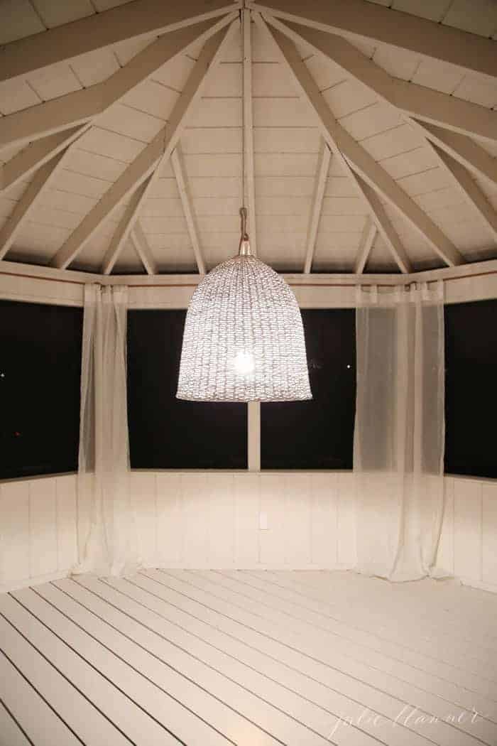 一个漂亮的篮子灯，晚上挂在门廊的屏风上。