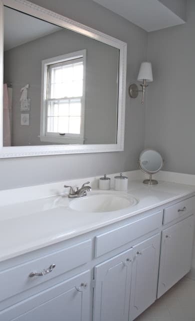 浴室有白色橱柜和灰色墙壁。