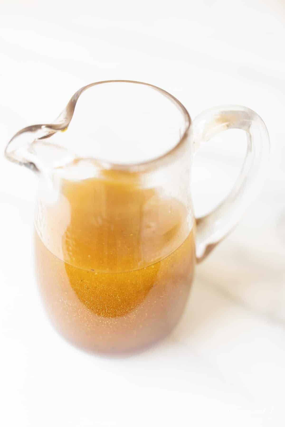 大理石表面有一个小罐装满了一个简单的自制醋汁配方。