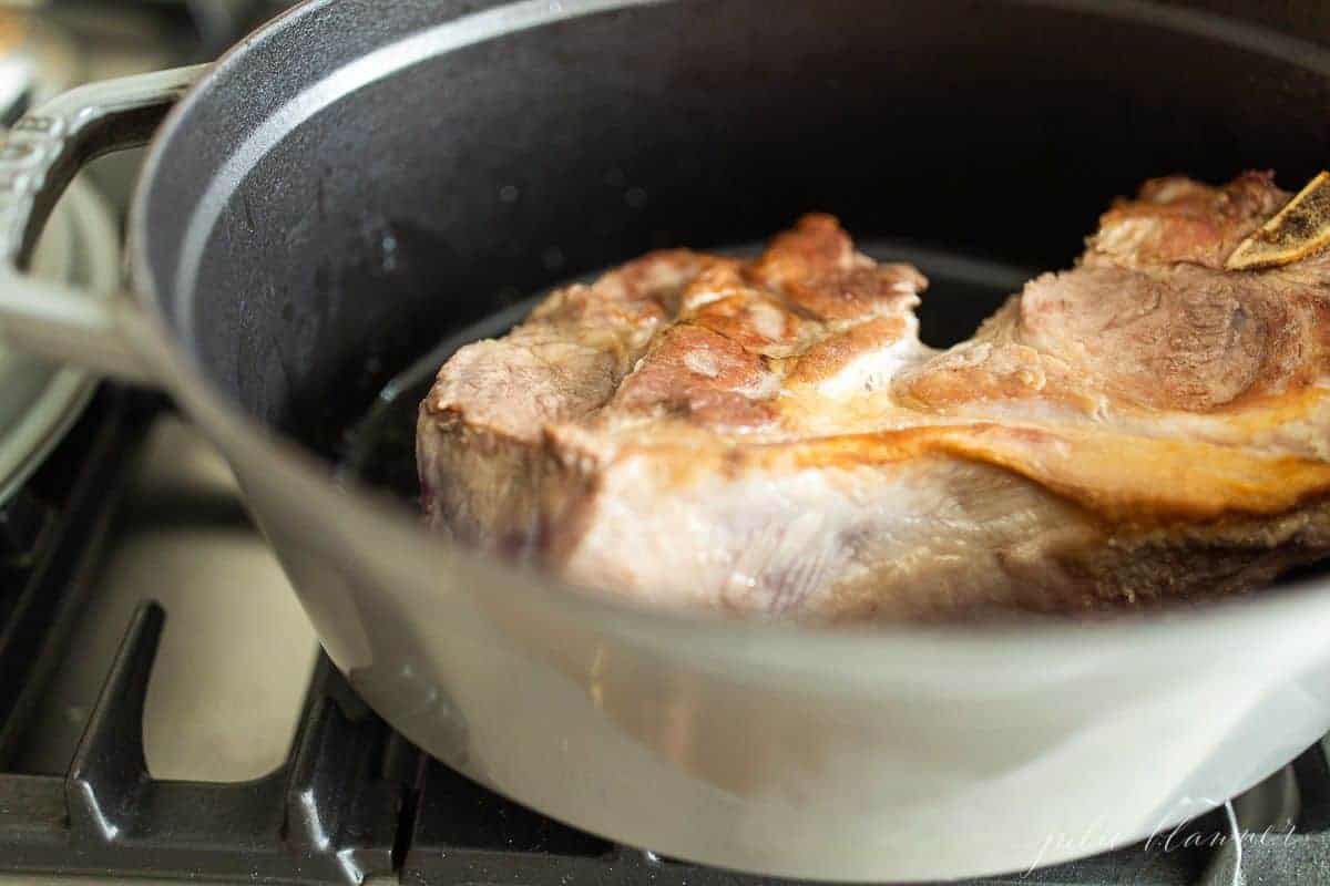 一种灰色的铸铁锅，里面装着棕色的猪肉，用来做肉酱gydF4y2Ba