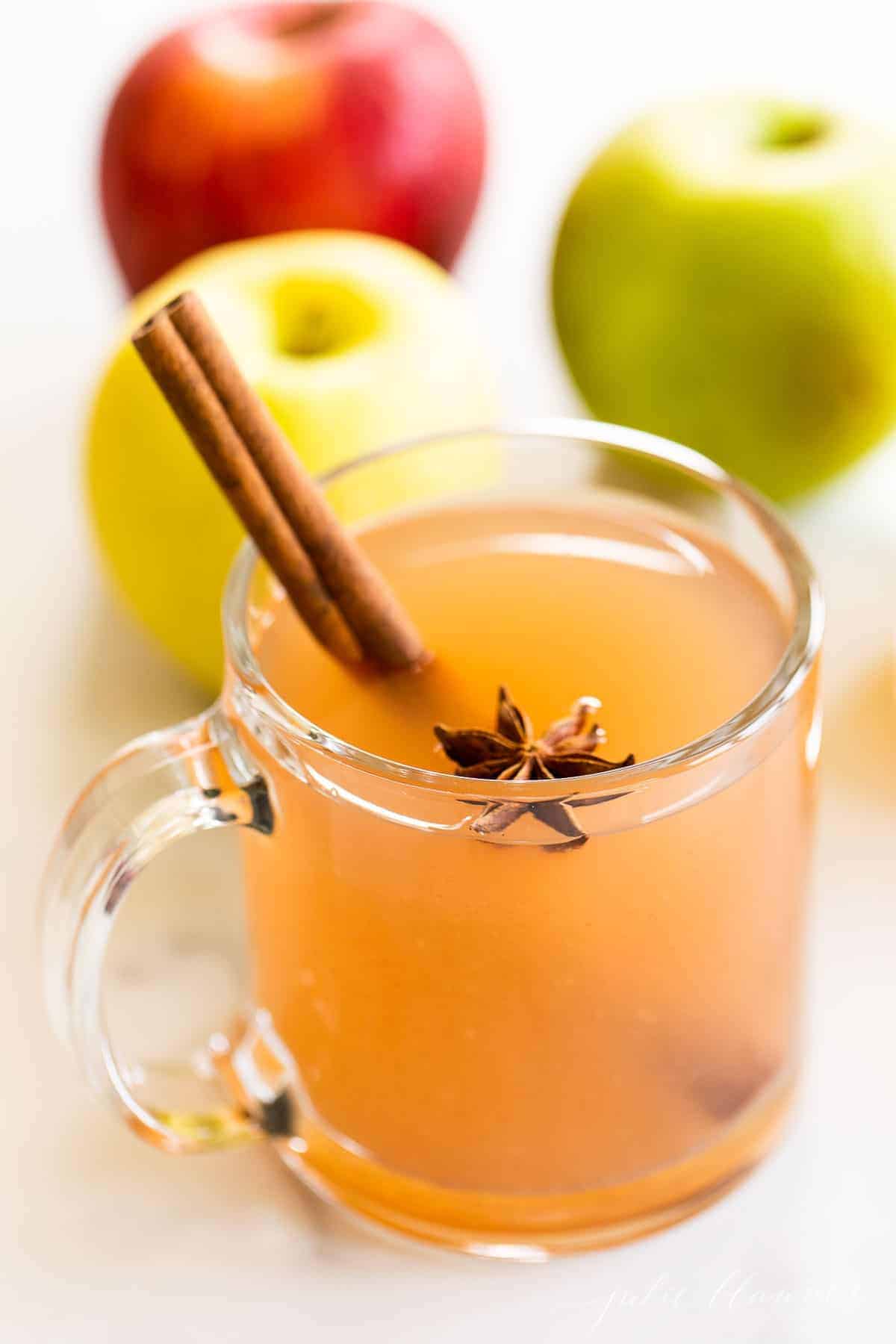 大理石的表面，清澈的杯子里装满了自制的苹果酒，整个苹果放在一边。gydF4y2Ba