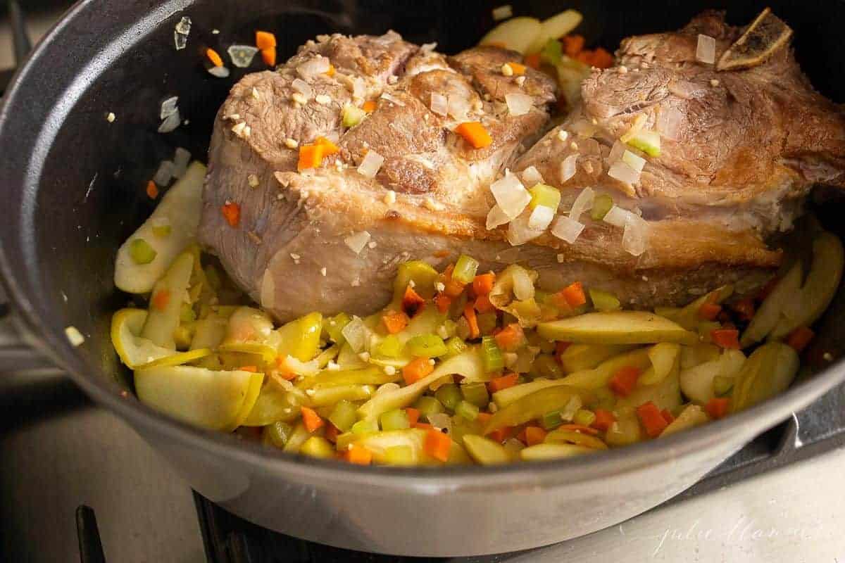 猪肩肉，配上熟苹果和蔬菜，放在铸铁锅里。gydF4y2Ba
