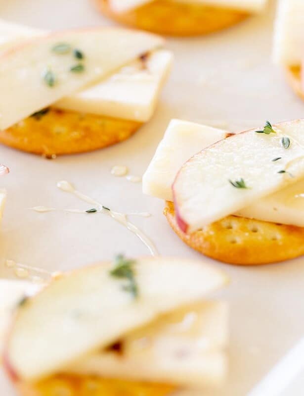 奶酪和饼干陈列品，苹果堆放在切达干酪上。