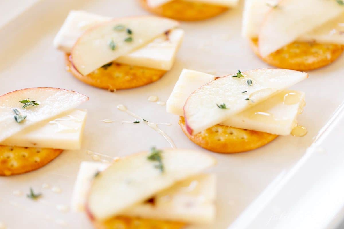 奶酪和饼干展示，苹果堆叠在切达干酪上。