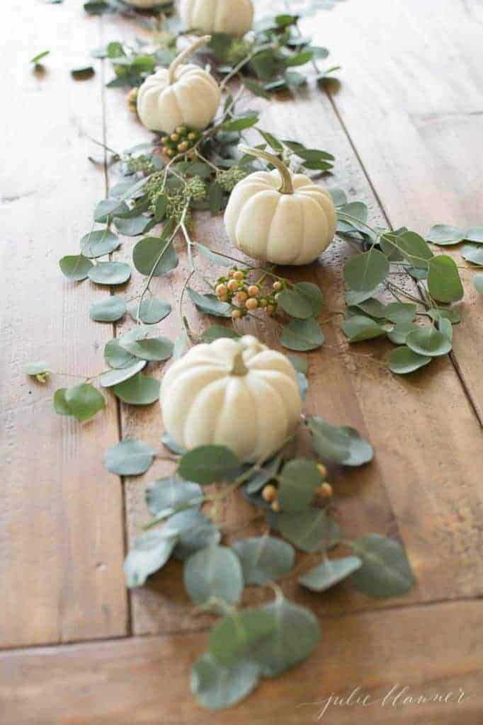 木桌上的南瓜和绿色植物的感恩节核心。