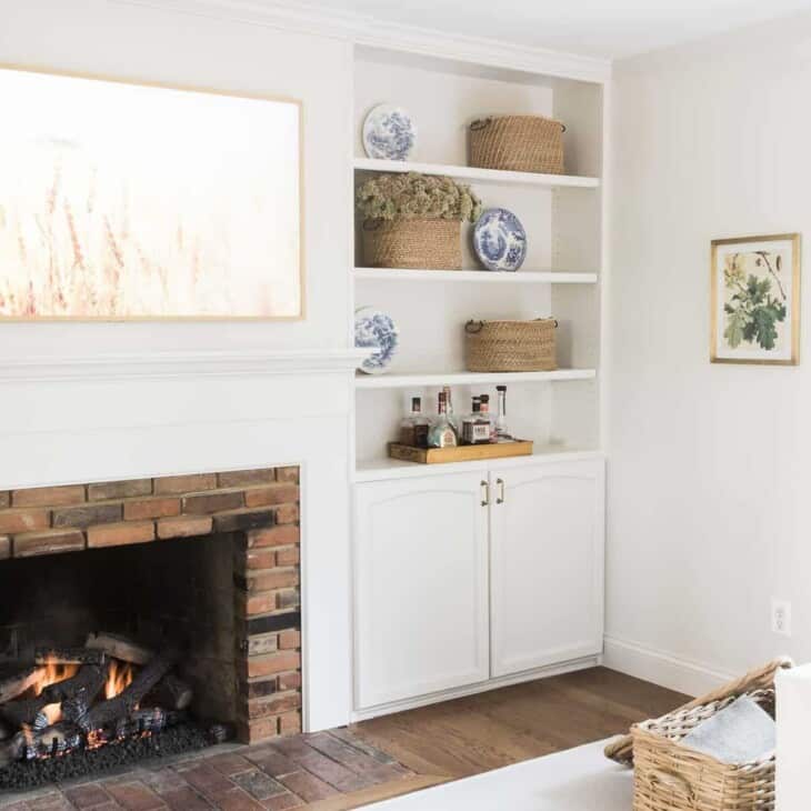 白色的客厅，壁炉，内置书架，以及在硬木地板上的客厅地毯。